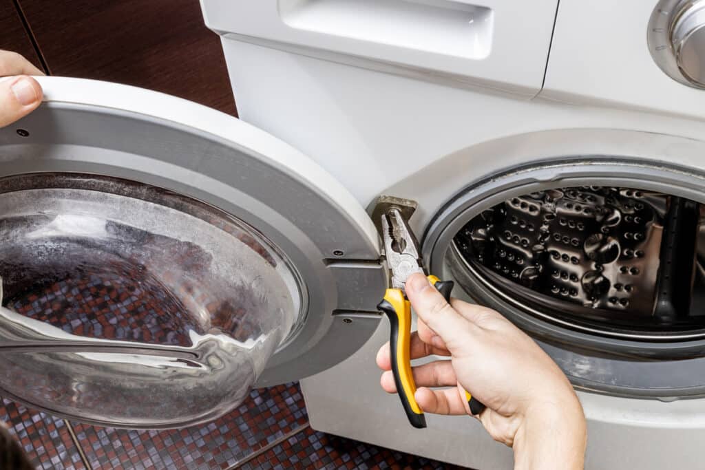 laundry washing machine repair concept. handyman fix washing appliance.